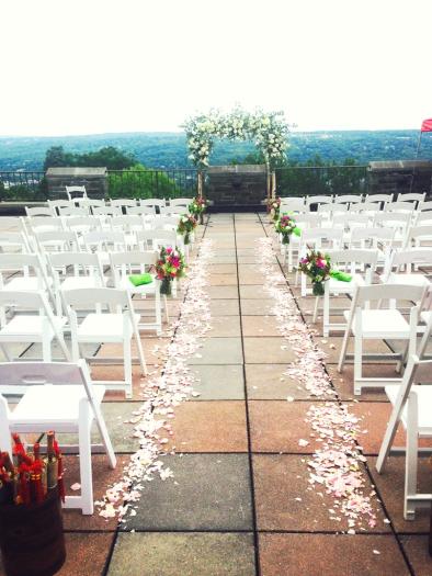 Rows of chairs set up for an event on an outdoor terrace