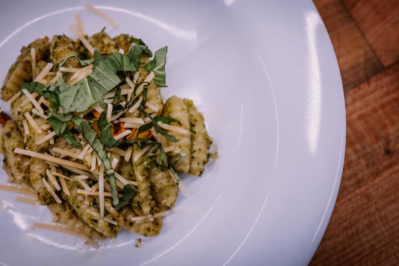 Plated pesto gnocchi with Parmesan cheese