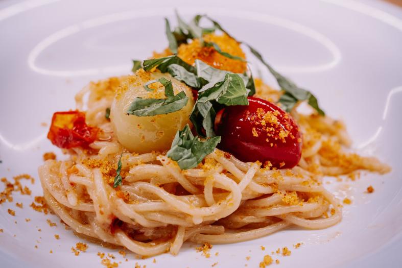 plated pasta with scallops and tomatoes.