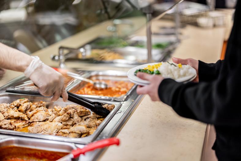 Cornell Dining staff serving at a buffet line.