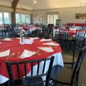 McCormick's Moakley Banquet Room.  The room is setup with round tables, red and white linens, and dishware.